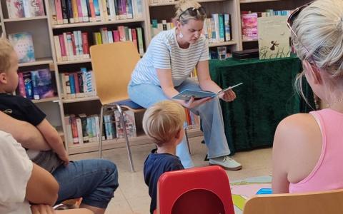 Kinder und Erwachsene hören einer Lesung zu